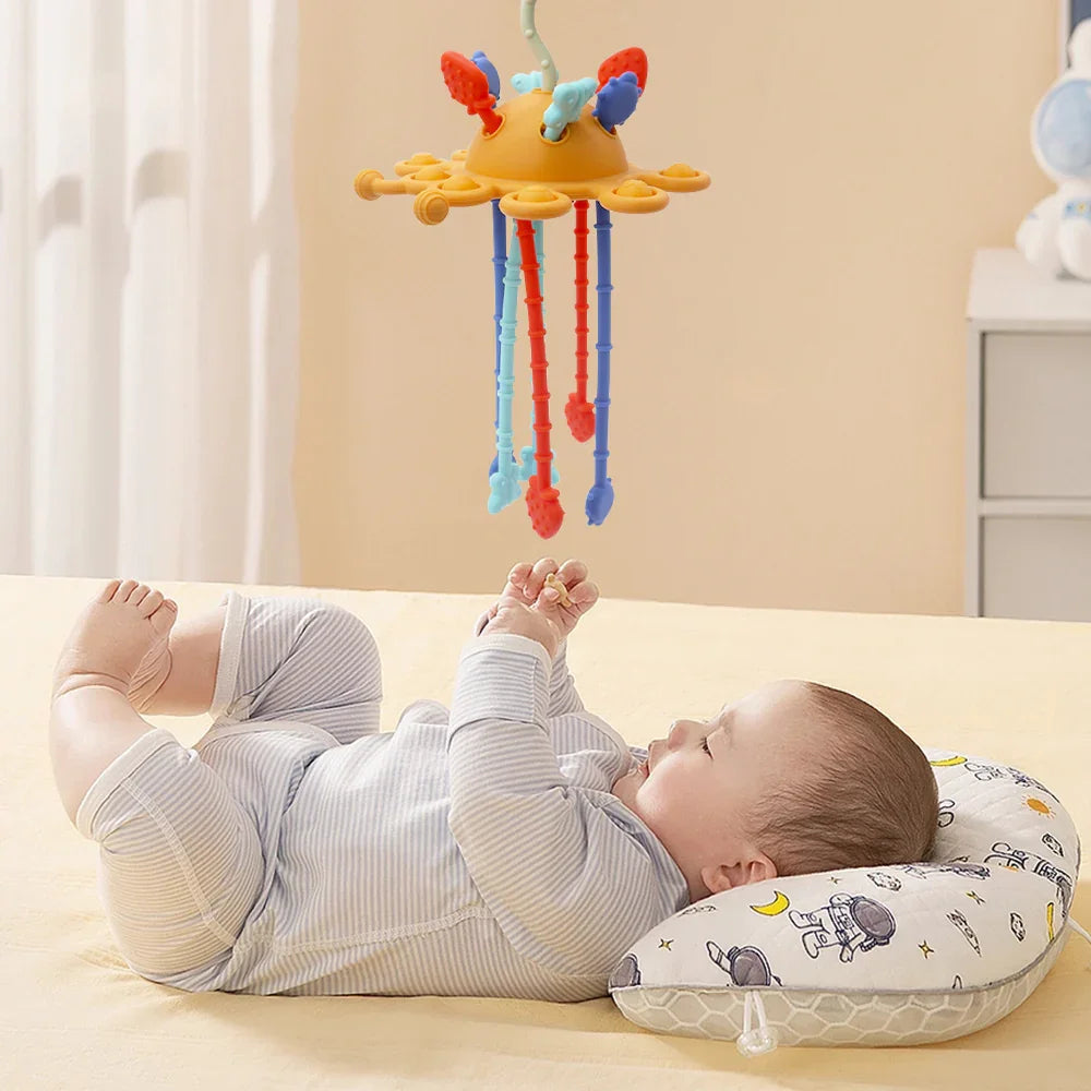 Bebé jugando con mordedor sensorial colgante en forma de chinita