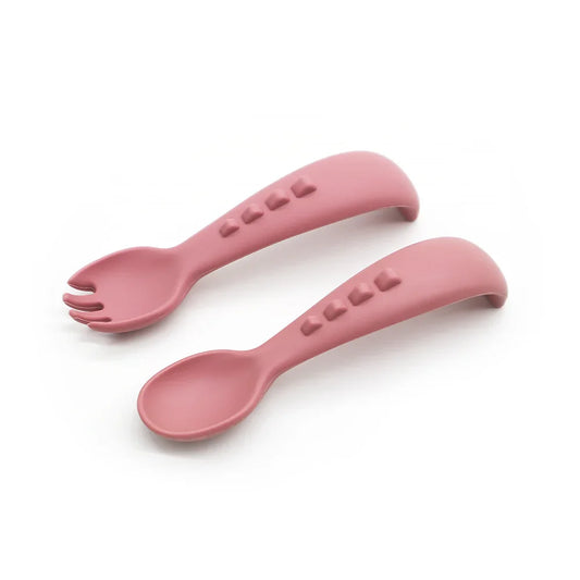 Set Dino Spoon y Dino Fork de silicona para bebés en color rosa oscuro, diseño ergonómico y seguro.