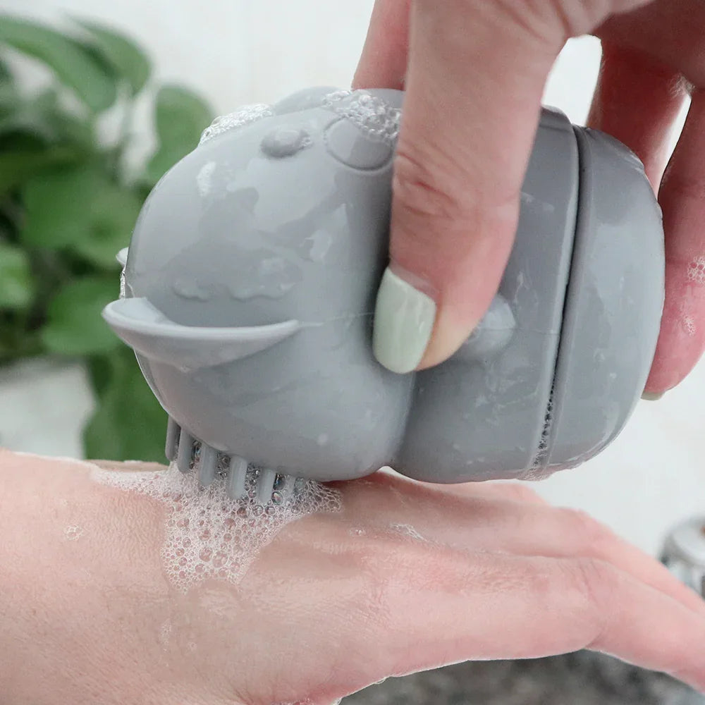 Juguete de baño de silicona gris utilizado con jabón y espuma.